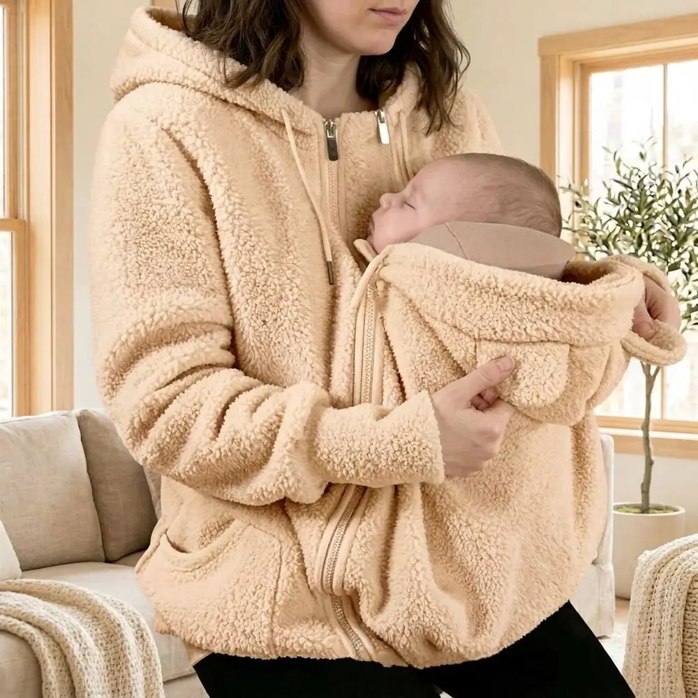 Baby sleeping snugly inside a Warmkind apricot teddy fleece hoodie