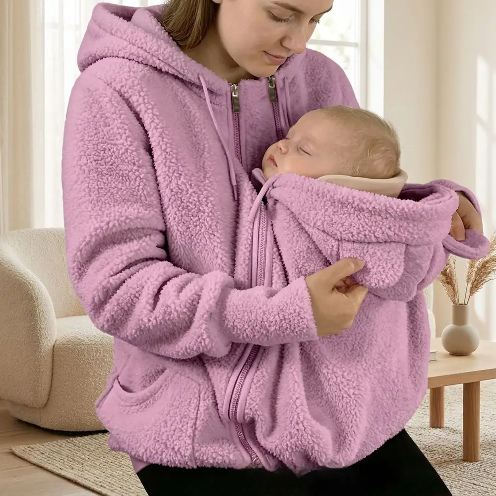 New mum keeping her baby close in a pink Warmkind fleece hoodie